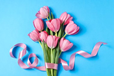 Açık mavi arka planda pembe laleler, üst manzara.