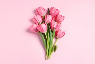 Pembe arka planda bir buket lale, üst manzara.