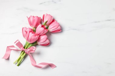 Beyaz mermer masa üzerinde pembe laleler, üst manzara. Metin için boşluk