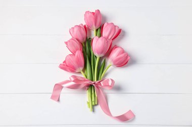 Beyaz ahşap masada pembe laleler, üst manzara.