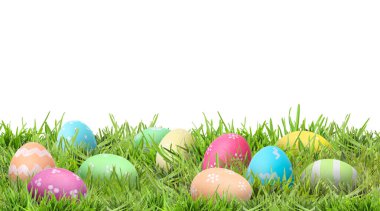 Beyaz arka plana karşı yeşil çimlerde paskalya yumurtaları