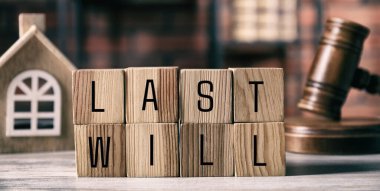 Son vasiyet. Harfli küplerden yapılmış kelimeler, yargıç tokmağı ve ahşap masa üzerindeki ev modeli, pankart tasarımı.