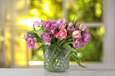 Pencerenin karşısındaki vazoda duran bir buket güzel lale.