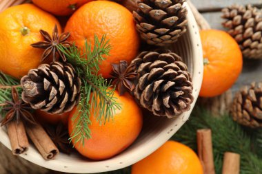 Masanın üzerinde olgun mandallar, baharatlar, koniler ve köknar ağacı dalları var.