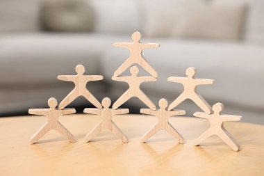 Denge oyunu. Ahşap akrobatları masaya istifleyin, yakın plan.