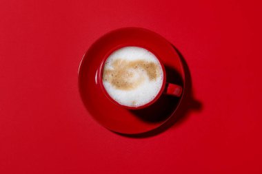 Kırmızı arka planda bir fincan aromatik kahve.