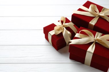 Sevgililer Günü. Beyaz ahşap masada güzel kadife hediye kutuları, yakın plan. Metin için boşluk