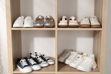 Raf ünitesinde farklı stil çocuk ayakkabıları var. Kapalı, yakın çekim.