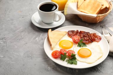 Yağda yumurta ve pastırmalı leziz kahvaltı, dokulu gri masada servis edilir. Metin için boşluk