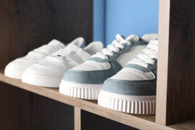 İçerideki ahşap raflarda farklı stil çocuk ayakkabıları, yakın plan.