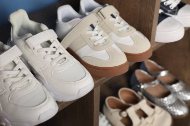 İçerideki ahşap raflarda farklı stil çocuk ayakkabıları, yakın plan.