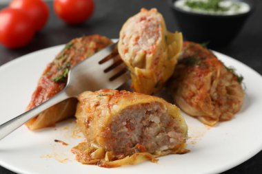 Siyah masada servis edilen lezzetli lahana dürümleri.