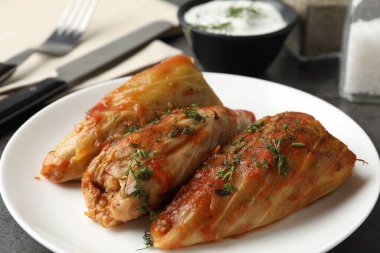 Gri masada servis edilen lezzetli lahana dürümleri, yakın plan.