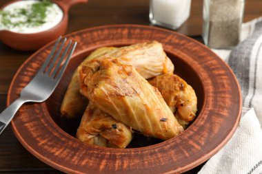 Tahta masada servis edilen lezzetli lahana dürümleri, yakın plan.