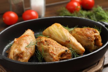 Tahta masada servis edilen lezzetli lahana dürümleri, yakın plan.