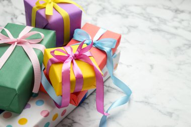 Beyaz mermer masadaki parlak hediye kutuları, yakın plan. Metin için boşluk