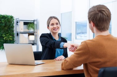Gülümseyen asker ve aday ofiste el sıkışıyor.