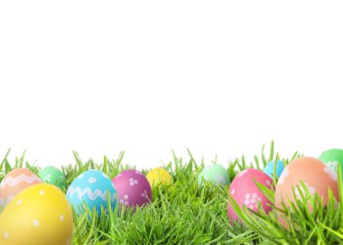 Beyaz arka plana karşı yeşil çimlerde paskalya yumurtaları