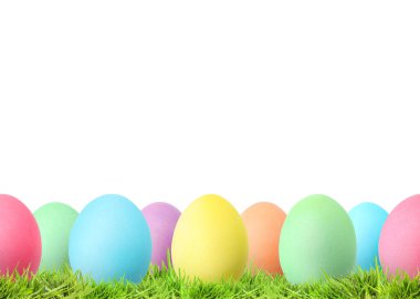 Beyaz arka plana karşı yeşil çimlerde paskalya yumurtaları