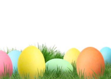 Beyaz arka plana karşı yeşil çimlerde paskalya yumurtaları