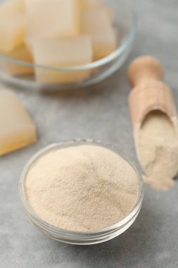 Jelatin tozu ve jöle küpleri gri masada, yakın plan.