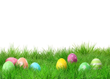 Beyaz arka plana karşı yeşil çimlerde paskalya yumurtaları