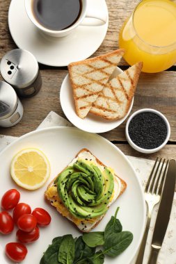 Tahta masada servis edilen avokado tostuyla nefis bir kahvaltı.