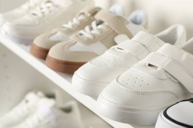 İçerideki raflarda farklı tarz çocuk ayakkabıları, yakın plan.