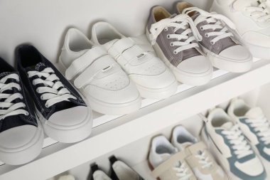 İçerideki raflarda farklı stil çocuk ayakkabıları, yakın plan.