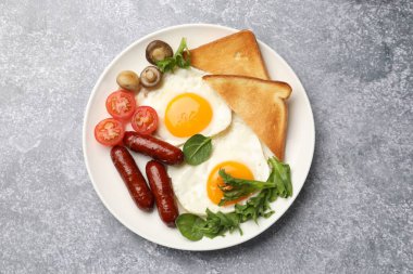 Yağda yumurta, sosis, tost, mantar ve domatesli nefis bir kahvaltı.