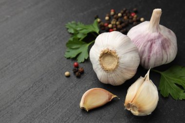 Taze sarımsak, biber ve maydanoz, siyah masada, yakın plan. Metin için boşluk