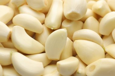 Arka plan olarak taze soyulmuş sarımsak karanfilleri, yakın plan