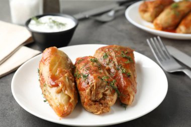 Gri masada servis edilen lezzetli lahana dürümleri, yakın plan.