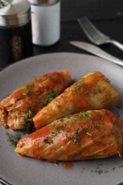 Siyah masada servis edilen lezzetli lahana dürümleri.