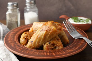 Tahta masada servis edilen lezzetli lahana dürümleri, yakın plan.