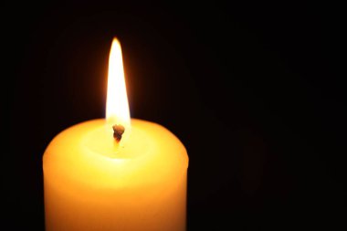 Siyah arka planda yanan bir mum, yakın plan. Metin için boşluk