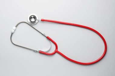 Açık gri arkaplanda kırmızı steteskop, üst görünüm