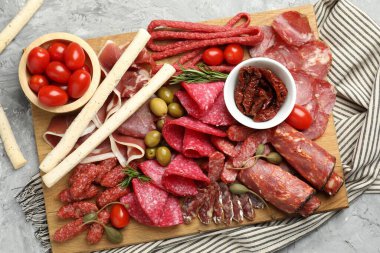 Farklı pişirilmiş et, sosis, zeytin ve domatesli şarküteri tahtası.