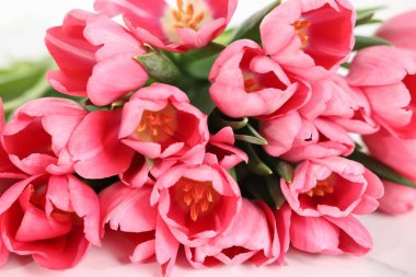 Beyaz masadaki pembe lale buketi, yakın plan.