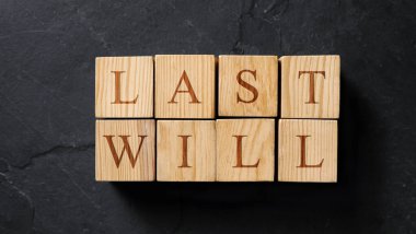 Son vasiyetnameler, siyah taş masanın üstünde harflerle yapılmış, üstten görülüyor. Pankart tasarımı