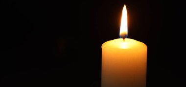 Siyah arka planda yanan bir mum, yakın plan. Metin için boşluk