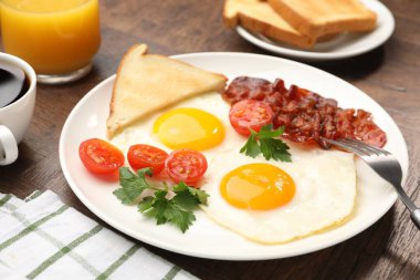 Yağda yumurta ve pastırma ile nefis bir kahvaltı, ahşap masada servis edilir, yakın plan.