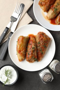 Gri masada servis edilen lezzetli lahana dürümleri.