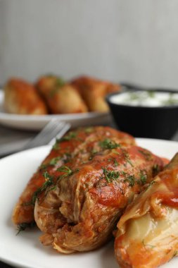 Gri masada servis edilen lezzetli lahana dürümleri, yakın plan.