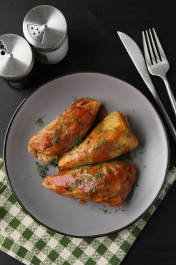 Siyah masada servis edilen lezzetli lahana dürümleri.