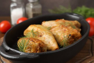 Tahta masada servis edilen lezzetli lahana dürümleri, yakın plan.