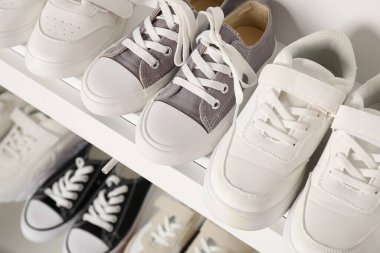 İçerideki raflarda farklı stil çocuk ayakkabıları, yakın plan.