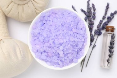 Beyaz arka planda mor deniz tuzu, bitkisel torbalar, gerekli yağ ve lavanta çiçekleri, düz yatıyordu.