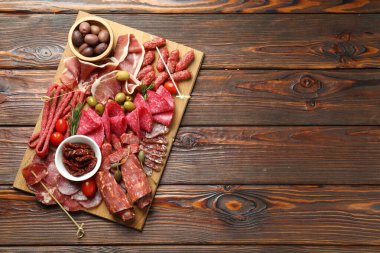 Şarküteri tahtası, farklı pişmiş et, sosis ve ahşap masa üzerinde zeytin, üst manzara. Metin için boşluk