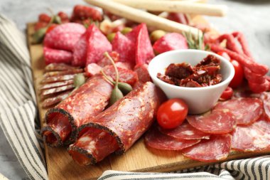 Farklı pişirilmiş et, sosis, zeytin ve domatesli şarküteri tahtası, yakın plan.